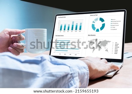 Businessman hand holding coffee cup with mockup chart presentation slide show on display laptop