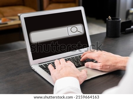 Businessman working on laptop and searching information on Internet. Screen with search bar icon. Man hands at keyboard closeup typing keywords. High quality photo