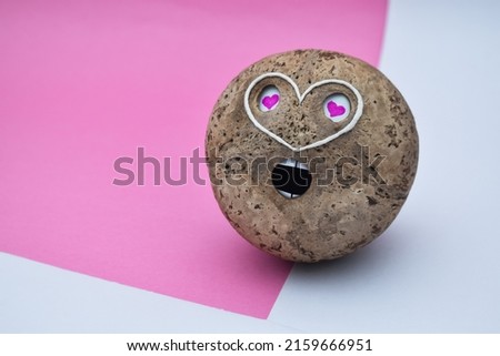 a coconut shell love emoji face object on white and pink background. Handmade design. 