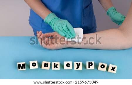 Doctor in medical gloves holds a syringe. Medical worker making a vaccine to a patient Medical supplies in a blue background. Monkeypox infection concept.