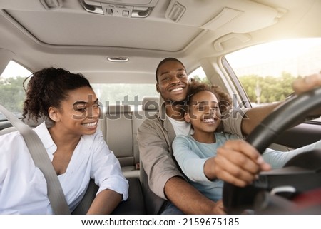 African American Father Teaching His Daughter To Drive Driving The Car Together. Happy Family Riding New Automobile In City, Having Fun Traveling By Auto. Vehicle Transportation Royalty-Free Stock Photo #2159675185