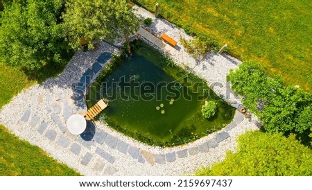 Garden pond. Relaxation zone with fish farming in an organic orchard from above. Sustainable development in gardening and aquaculture.