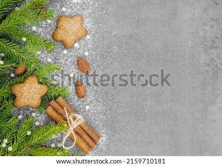 Christmas winter background. Spicy ginger cookies, pretzels, flour. Copy space. Slate and snow. Fir twigs with cinnamon and almonds
