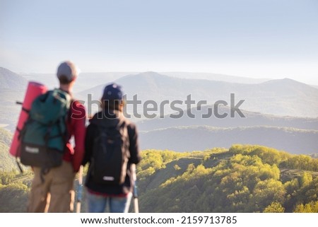 young couple, man and  woman, together hiking through the mountains