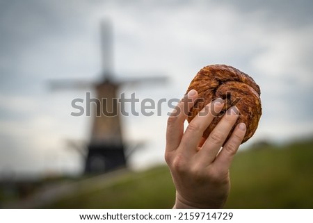 Traditional dutch pastry called Zeeuwse Bolus on blurred background with a windmill Royalty-Free Stock Photo #2159714729