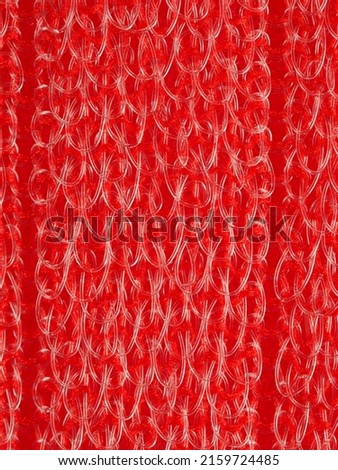 close up, background, texture, large vertical banner. heterogeneous surface structure bright saturated red sponge for washing dishes, kitchen, bath. full depth of field. high resolution photo
