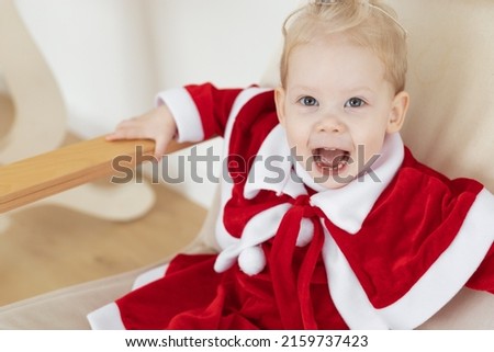 Child girl dressed in christmas dress with cochlear implants having fun at home - hearing aid and innovating technologies for treatment of deafness, copy space