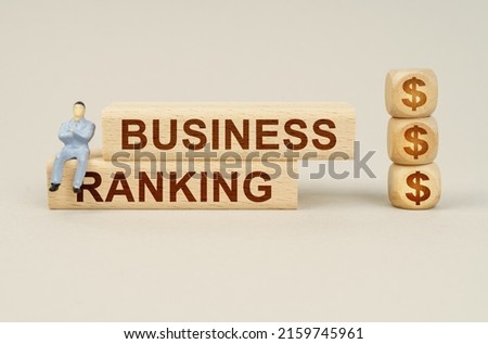 Business concept. Cubes with the image of the symbol of the dollar, on the blocks with the inscription - BUSINESS RANKING, sits a figure of a businessman.