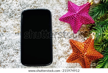 Christmas decorations and telephone on a dark wood background. tinting. selective focus on the telephone