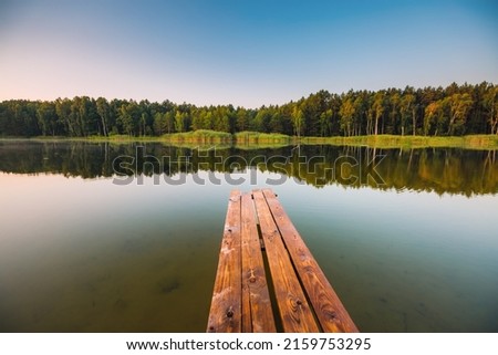 Wooden pier on a quiet lake in the morning. Location place Small Polissya, Ukraine, Europe. Photo of nature concept. Perfect summertime wallpaper. Discover the beauty of earth.