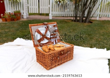 a picnic basket on the lawn of the backyard
