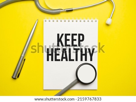 The words keep healthy, is written on white paper on yellow background