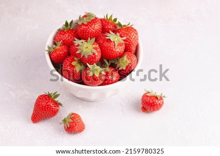 White bowl of fresh red strawberries closeup