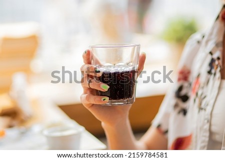 person holding a glass of red wine drink or cola