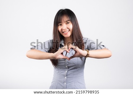 Woman smiling confidence make finger heart gesture figure symbol shape sign with two hands isolated white background, Asian happy portrait beautiful young female send love and happy valentine