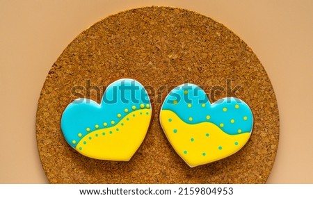 Heart shape ukrainian colours blue and yellow national flag gingerbread candies brown cork texture background.