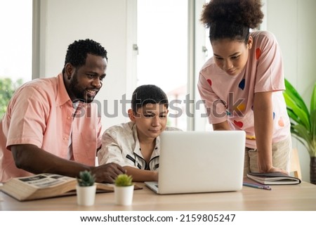 Part-time teacher with children Search the Internet to compare it with information from old books. Special classroom. Concept Home school, teaching modifications for children.