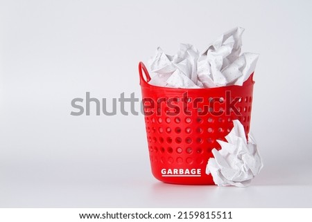 Trash can. Full basket. Crumpled paper in a basket. A mountain of garbage is scattered on the table.