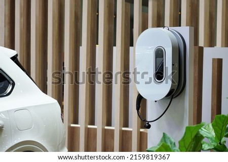 Electric home charger for EV car (electric car) in the home garage. Royalty-Free Stock Photo #2159819367