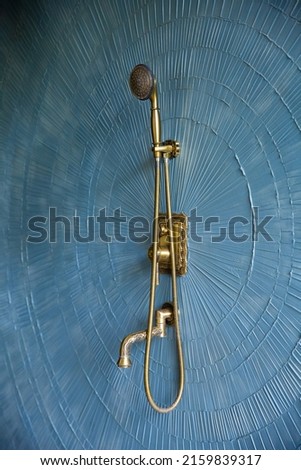 gold watering can in spa house shower room tropical shower blue design  Royalty-Free Stock Photo #2159839317