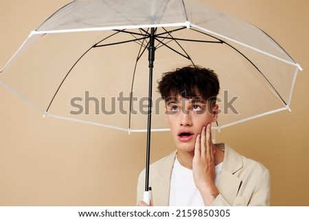 photo of a young guy in a white jacket with an open umbrella