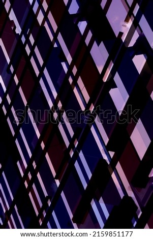 Colorized photo of structural glazing. Windows of hi-tech building. Abstract modern architecture at sunset. Geometric background or glass wall. Polygonal pattern of reflecting panels.