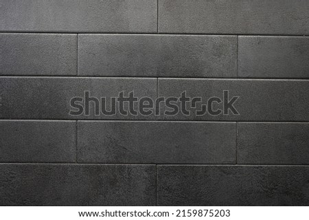 Dark gray brick tiles wall texture. Ceramic tile pattern. 