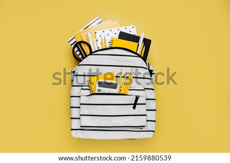 Opened School backpack with stationery on yellow background. Concept back to school. School supplies with white school bag. Royalty-Free Stock Photo #2159880539