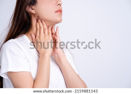 Sore throat. Closeup of beautiful young woman hand touching her ill neck. She suffering from throat pain, painful swallowing. Royalty-Free Stock Photo #2159881143