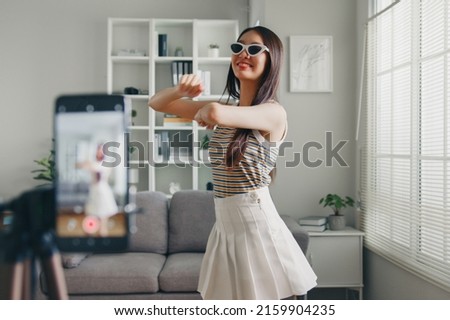 Asian young woman tiktoker created her dancing video by smartphone camera. To share video on social media application Royalty-Free Stock Photo #2159904235