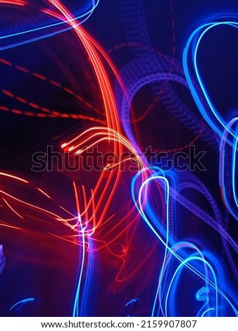 Blue and red light painting photography, long exposure fairy blue and red lights curves and waves against a black background. Abstract motion curvy urban road with neon light motion effect applied .