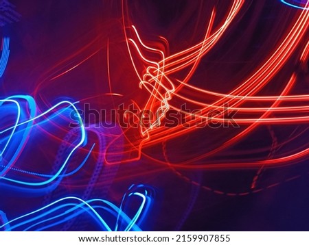 Blue and red light painting photography, long exposure fairy blue and red lights curves and waves against a black background. Abstract motion curvy urban road with neon light motion effect applied . Royalty-Free Stock Photo #2159907855