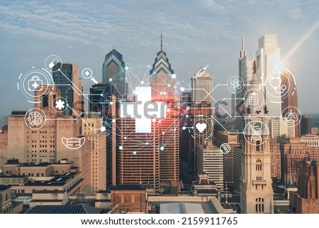 Aerial panoramic cityscape of Philadelphia financial downtown, Pennsylvania, USA. City Hall Clock Tower, sunrise. Hologram healthcare digital medicine icons. The concept of treatment from disease