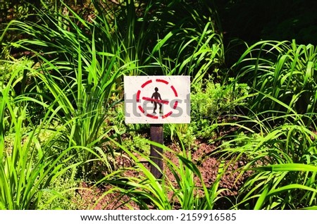 Do not go on the lawn sign. Do not go on the grass sign. Do not cross sign. Crossed by red line black silhouette of human being in the red circle.
