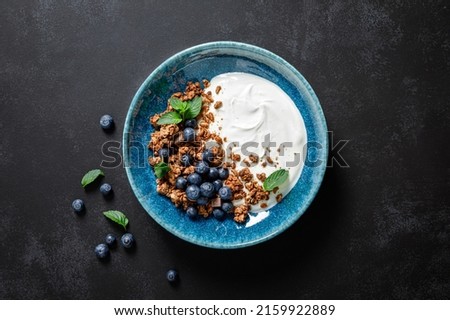 Chocolate granola with white plain yogurt and fresh blueberry in a bowl, healthy food for breakfast, top view Royalty-Free Stock Photo #2159922889