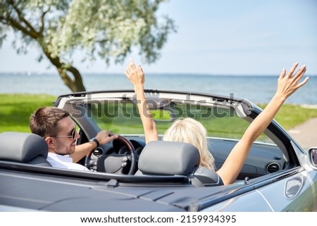 road trip, travel and tourism concept - happy couple driving in convertible car Royalty-Free Stock Photo #2159934395