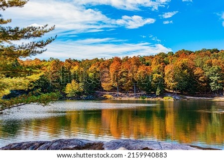 Small lake at the edge of the forest. Omega Park is a natural eco-park among meadows, forests and valleys. Journey to beautiful Canada. Province of Quebec. Northern autumn. 