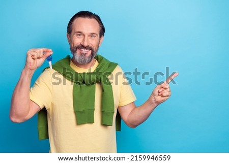 Photo of positive person demonstrate hold key indicate finger empty space isolated on blue color background