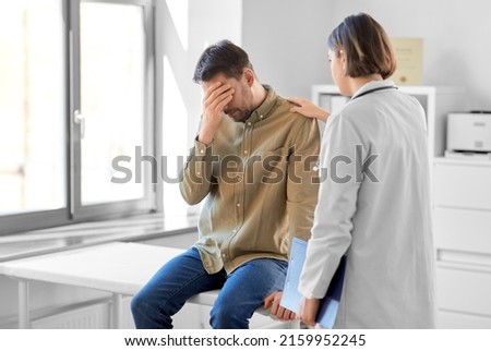 medicine, healthcare and people concept - female doctor with clipboard and sad male patient having health problem at hospital Royalty-Free Stock Photo #2159952245