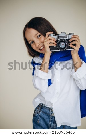 Cute girl holding camera and smiling