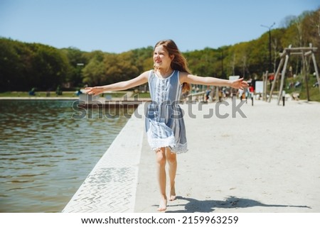 happy child on the beach.little blonde girl runs along the sand on the beach.