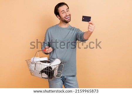 Photo of young man make shopping consumer bank card black friday benefit isolated over beige color background