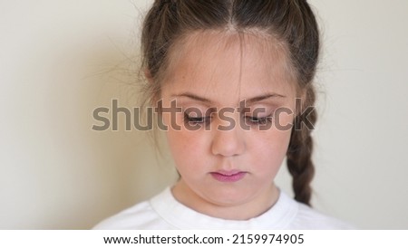 portrait child girl looking at the camera. happy family kid dream concept. baby eyes down then look at the camera and smiles. portrait girl kid indoors close-up. smile funny teeth fell out