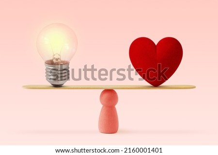 Light bulb and heart on scale on pink background- Concept of woman and balance between heart and brain