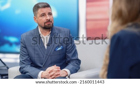 Talk Show TV Program: Professional Cable Channel Host Interviews Guest. Presenters Talk, Discuss News, Politics, Science, Gossip, Celebrity and Entertainment. Mock-up Television Studio Royalty-Free Stock Photo #2160011443