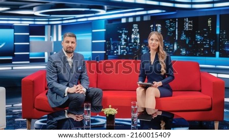 Talk Show TV Program: Two Professional Presenters Talk, Discuss News, Politics, Science, Celebrity and Entertainment. Cable Channel Host Interviews Guest. Mock-up Television Studio. Royalty-Free Stock Photo #2160015409