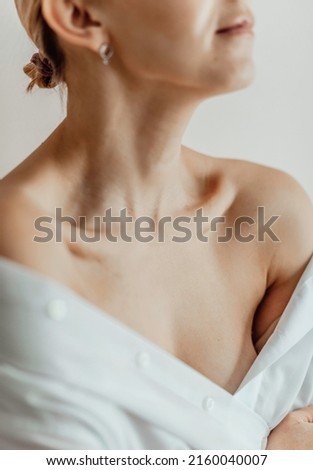 Close-up of a young woman's neck, collarbone, chest. Lines on the neck. Wrinkles, age-related changes, rings of Venus, goosebumps.