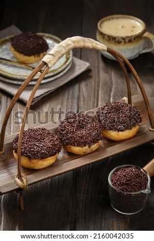 donuts on a bamboo tray, topped with chocolate messes. soft focus texture, grainny