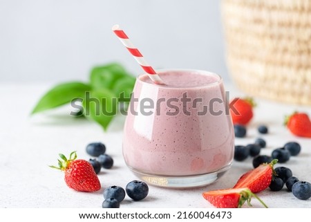 Delicious pink berry fruit smoothie in glass. Healthy vegan smoothie or vegan milkshake with soy milk and berries Royalty-Free Stock Photo #2160046473