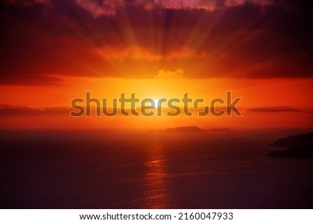 Great dramatic view. Red sun in the clouds. Meditative calmness and greatness. Amazing sky panorama. Colorful sunset in the evening sky. Clouds illuminated by the setting sun.